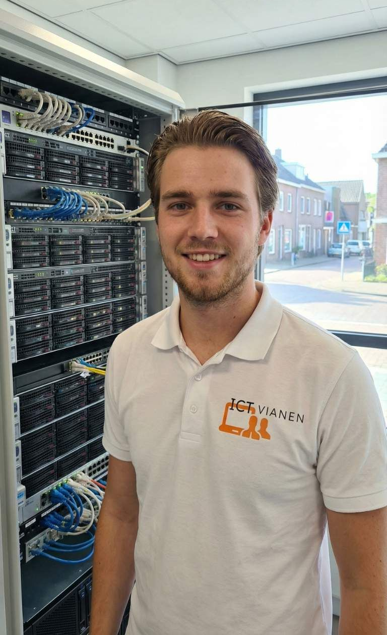 Mick Mulder van ICT Vianen in bedrijfskleding bij de serverkast op kantoor in Vianen