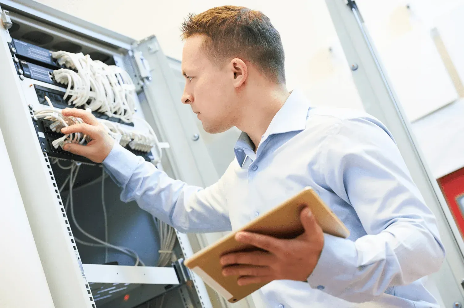 Netwerkkast met bekabeling en een router aan de muur